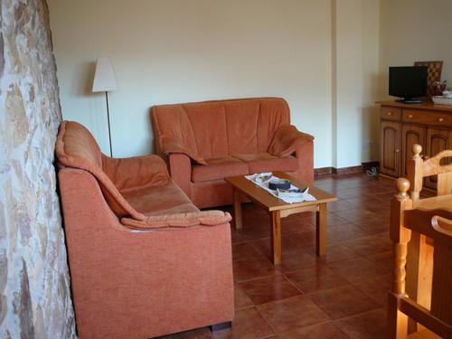 ein Wohnzimmer mit 2 Stühlen und einem Tisch in der Unterkunft Casa Numero 4 a un paso de la playa in Cudillero