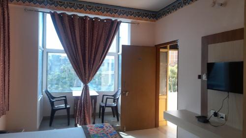 a room with a window with chairs and a table at Hotel Braj Haveli in Jaipur