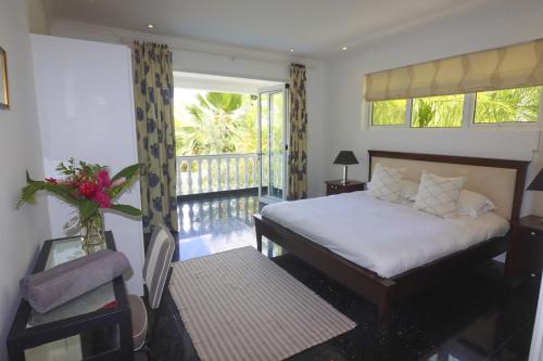 a bedroom with a bed and a balcony at Chateau Elysium - Two bedroom villa 1 in Beau Vallon