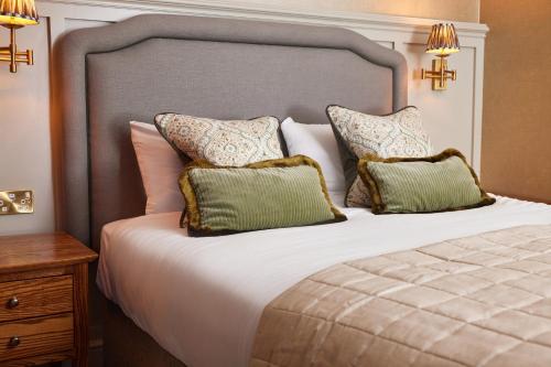 a bedroom with a large bed with two pillows at Dog and Partridge by Greene King Inns in Bury Saint Edmunds