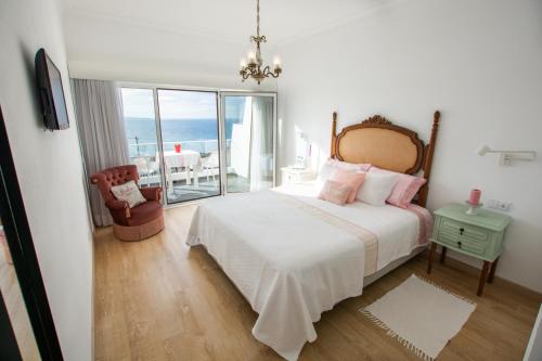 een slaapkamer met een bed en uitzicht op de oceaan bij Vila Fortaleza in Aljezur