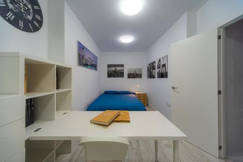 Habitación blanca con mesa y reloj en la pared en Chalet con piscina a 20 minutos de Sierra Nevada, en Cenes de la Vega