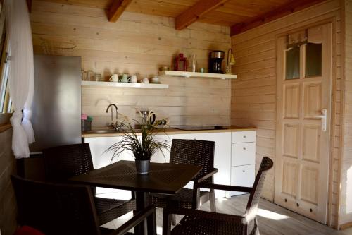 a kitchen with a table and chairs and a refrigerator at Camping Szczecinek Domy Wypoczynkowe in Szczecinek