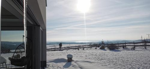 a snow covered yard with the sun in the sky at Relax V Kraji in Žernov
