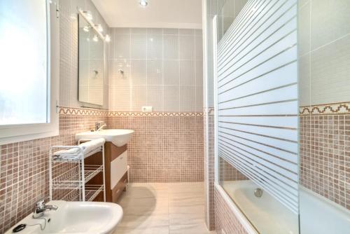 卡爾佩的住宿－Bungalow Rosa - PlusHolidays，浴室配有水槽、淋浴和浴缸。