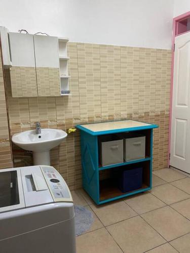 uma pequena casa de banho com um lavatório e um armário azul em grounfloor flat furnished swimming pool em Flic-en-Flac