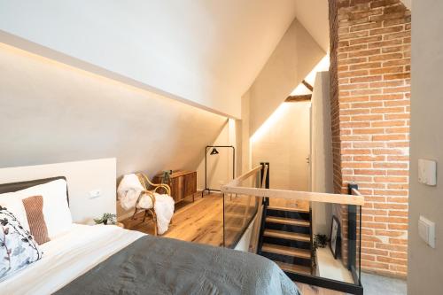 een slaapkamer met een bed en een bakstenen muur bij Luxury Penthouse on the Lake in Überlingen
