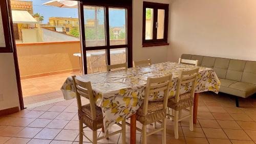 uma mesa de jantar e cadeiras com uma mesa e um sofá em Casa Giusy em Terrasini