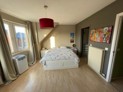 een slaapkamer met een bed en een groot raam bij Maison de vacances moderne et spacieuse situé à 20 minutes de BXL, Antwerp & Gent in Merchtem