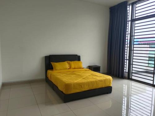 um quarto com uma cama com lençóis amarelos e uma janela em Homestay Desaru Utama @Escadia em Bandar Penawar