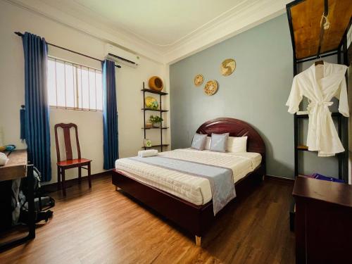 a bedroom with a bed and a chair in it at Dom Hostel and Bar in Hoi An