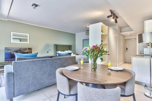 a kitchen and living room with a table and a couch at Harbour Bridge Waterfront in Cape Town