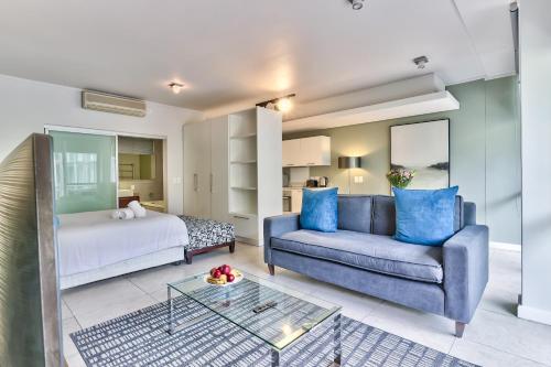 a living room with a couch and a bed at Harbour Bridge Waterfront in Cape Town