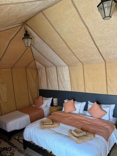 two beds in a room in a tent at Camel Luxury Camp in Merzouga