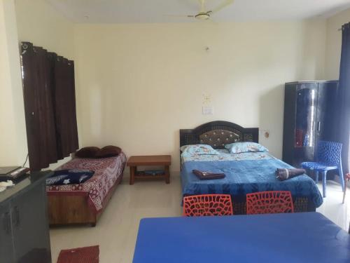 a room with two beds and a table in a room at Nandi Skandagiri Guest House in Nandi