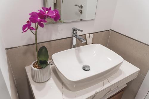 a bathroom sink with a purple flower in a vase at New 2 bedroom entire apartment in Madinat Jumeirah Living in Dubai