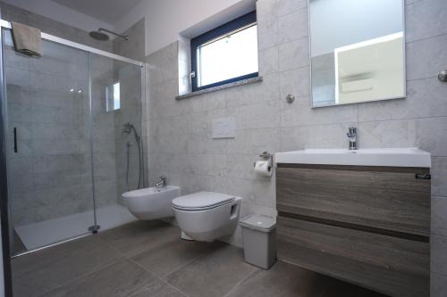 a bathroom with a toilet and a sink and a shower at Villa Jacky in Poreč