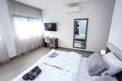 a bedroom with a white bed and a mirror at Villa Jacky in Poreč