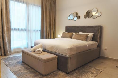a bedroom with a large bed and a ottoman at New 2 bedroom entire apartment in Madinat Jumeirah Living in Dubai