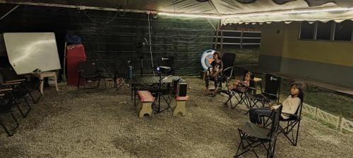 a group of people sitting in chairs in a tent at Teniat Village in Rantau Panjang
