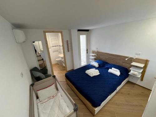 a bedroom with a blue bed with towels on it at La Casina a Treggiaia in Treggiaia