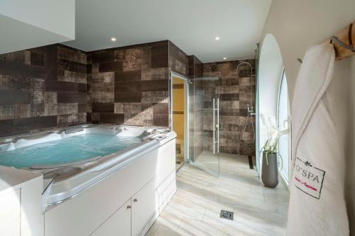 a bathroom with a tub and a shower at Best Western Plus Villa Saint Antoine Hotel & Spa in Clisson