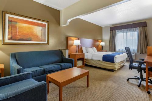 Habitación de hotel con cama, sofá y escritorio en Comfort Suites Auburn Hills-Detroit, en Auburn Hills