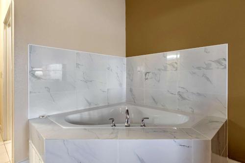 a white tub in a bathroom with white marble at Comfort Suites Auburn Hills-Detroit in Auburn Hills