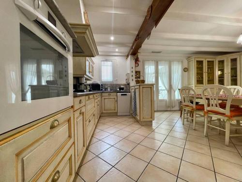 une grande cuisine avec une table et des chaises. dans l'établissement Villa Anatole - parking privé - 900m Cité Médiévale, à Carcassonne