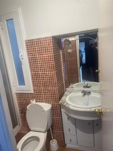 y baño con aseo y lavamanos. en Apartemento passeig de ronda en Lleida