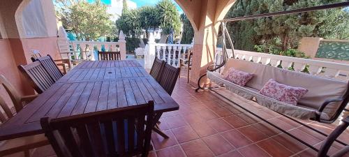 2 mesas de madera y sillas en un patio en Chalet los sauces, en Cabo de Palos