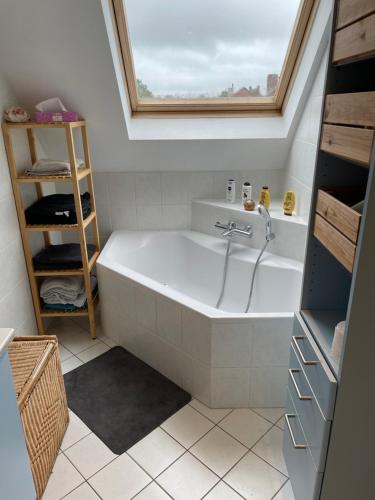 a bathroom with a bath tub with a window at Maison de vacances moderne et spacieuse situé à 20 minutes de BXL, Antwerp & Gent in Merchtem