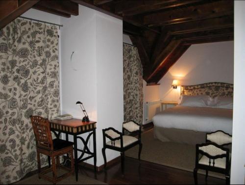 トレドスにあるCasa Valle de Arán - Baqueiraのベッドルーム1室(ベッド1台、テーブル、椅子付)