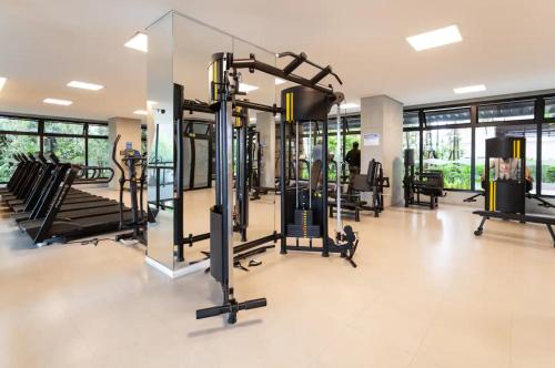 een fitnessruimte met loopbanden en crosstrainers in een gebouw bij Resort, Piscina e Natureza em SP in Sao Paulo
