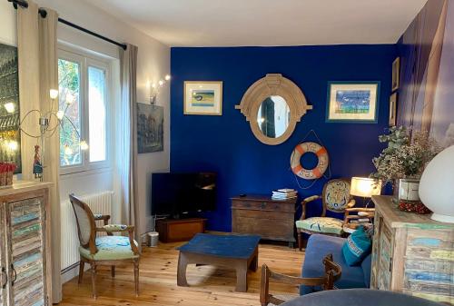 uma sala de estar com uma parede azul em VILLA LES TERRASSES dans la nature avec piscine à 2 pas de Lyon, métro à 15mn à pied pour Lyon centre en 10mn ou bus à 300m pour Lyon centre em Oullins