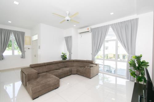 a living room with a couch and a ceiling fan at Beach side spacious 5BR 20pax pool house in Batu Ferringhi