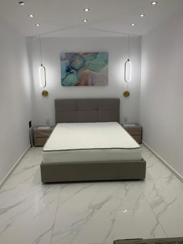 1 dormitorio con 1 cama en una habitación blanca en ΟΙΚΙΑ ΑΠΟΖΑΡΙ ΜΕΓΑΛΗ ΠΕΡΣΑ en Kastoria