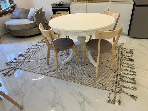 a table and four chairs and a table and a table at ΟΙΚΙΑ ΑΠΟΖΑΡΙ ΜΕΓΑΛΗ ΠΕΡΣΑ in Kastoria