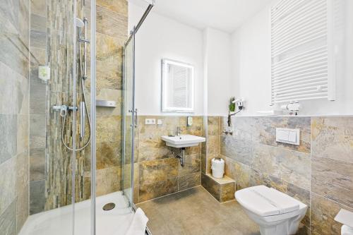 uma casa de banho com um chuveiro, um WC e um lavatório. em Hotel Phoenix em Berghausen