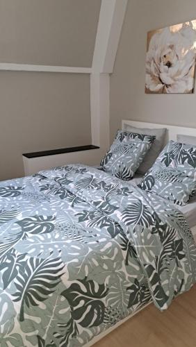 a bedroom with a bed with a blue and white comforter at chambre cocooning in Annappes