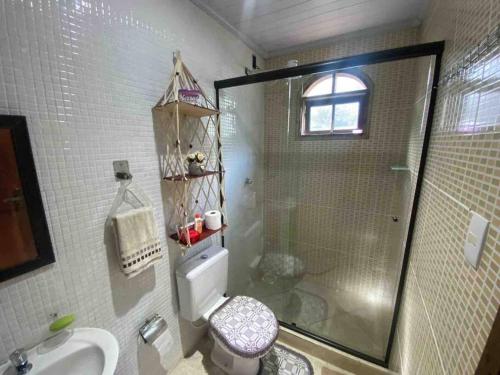 a bathroom with a shower and a toilet and a sink at Chácara Paraíso Escondido in Angra dos Reis