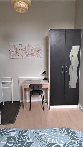 - une chambre avec un bureau et une porte avec une chaise dans l'établissement chambre cocooning, à Annappes