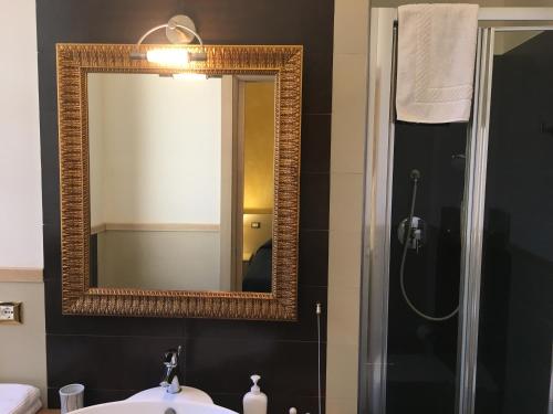 een badkamer met een spiegel, een wastafel en een douche bij BeBIGEA Siracusa in Siracusa