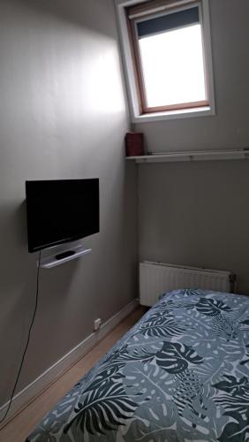 a bedroom with a bed and a flat screen tv at chambre cocooning in Annappes