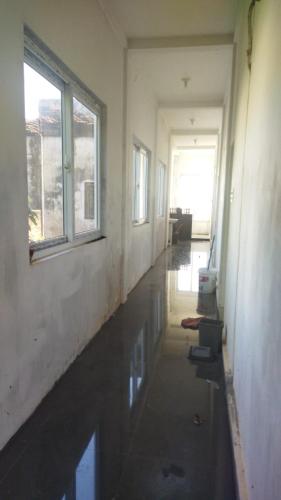un pasillo vacío de una casa con agua en el suelo en Ammaro Homestay and Cafe, en Meulaboh