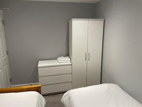 a bedroom with a white cabinet and two beds at Vale NKY Apartment Rooms in London