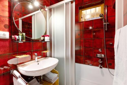 a red bathroom with a sink and a mirror at Appartamento Cesa Wanker in Ortisei