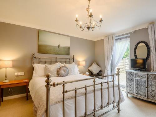 a bedroom with a bed and a television and a chandelier at 1 Bed in Skegness 77586 in Croft