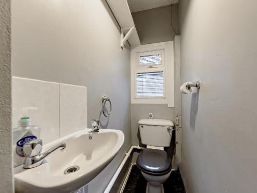 La petite salle de bains est pourvue de toilettes et d'un lavabo. dans l'établissement 3 Bed in Tenby FB063, à Tenby