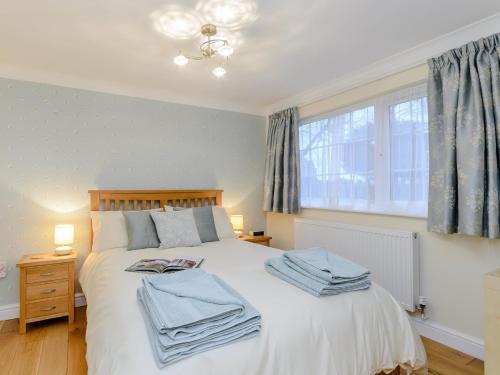 a bedroom with a white bed with blue towels on it at 1 Bed in Whatton 77805 in Bingham